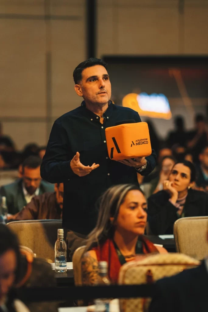 Participante recebendo o material da imersão na plateia